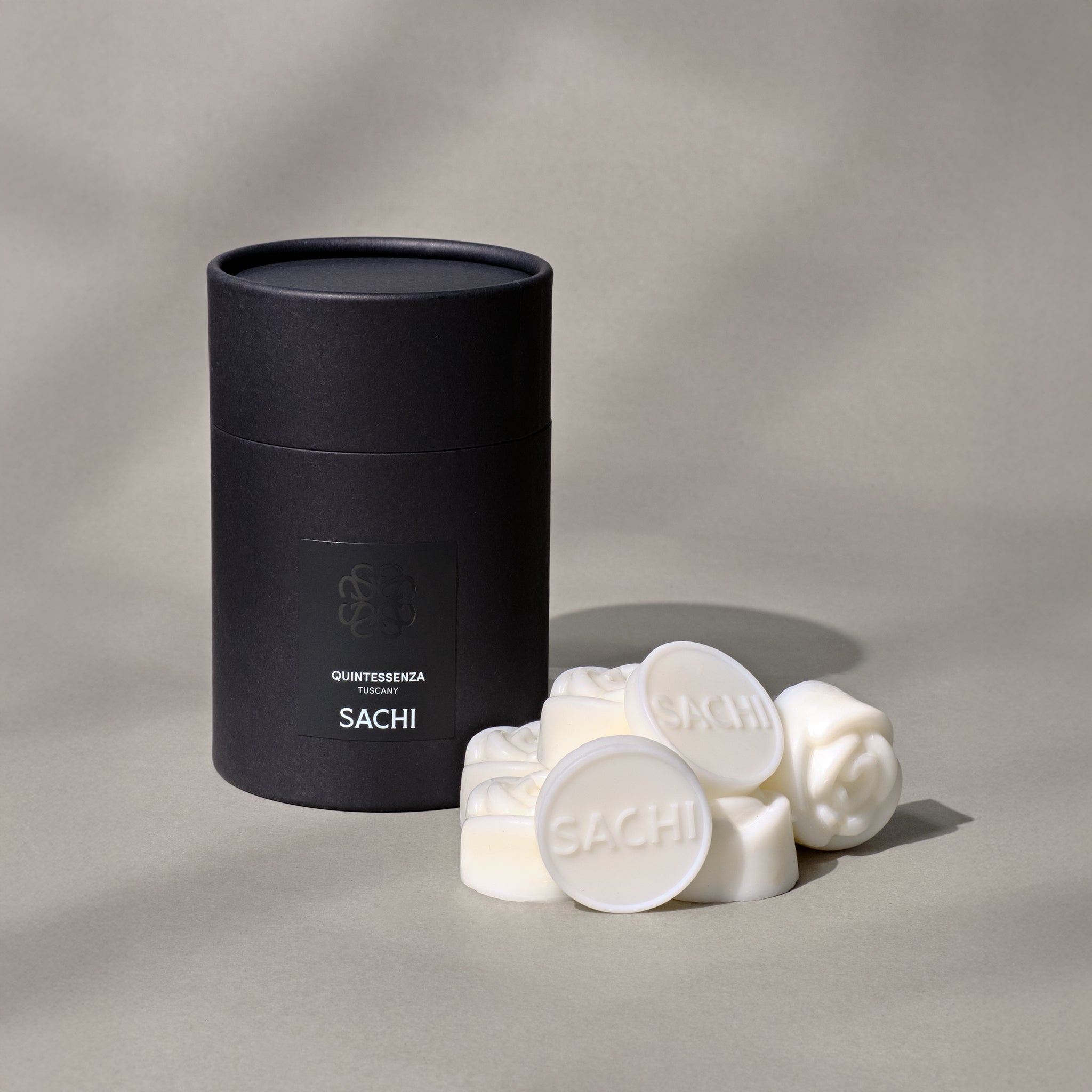 Black tubular presentation box branded with Sachi and several ivory wax melts